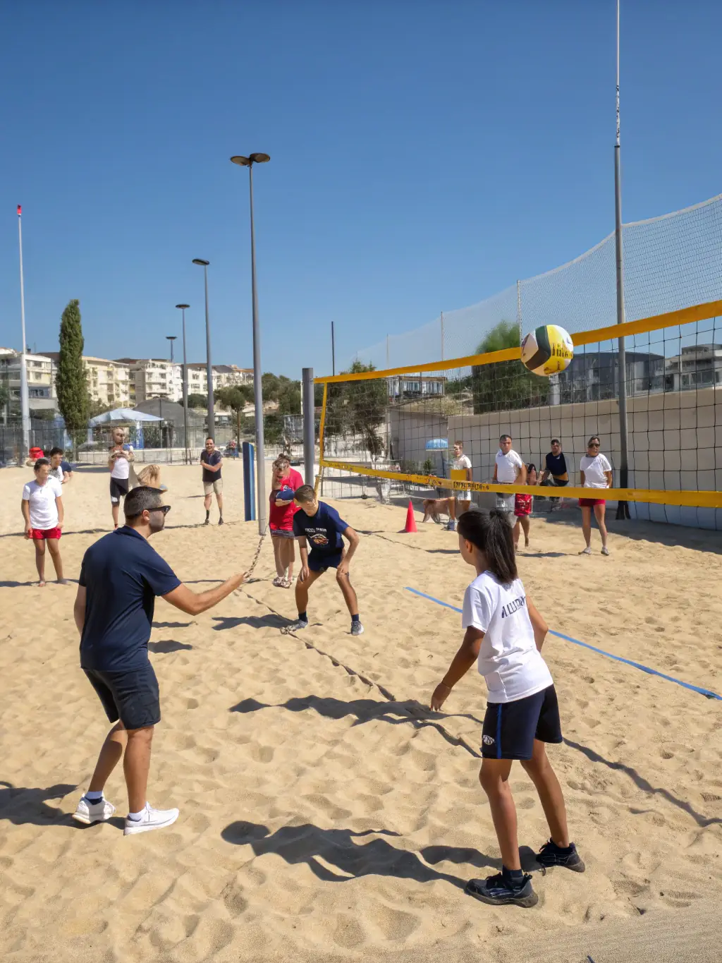 A vibrant action shot of young children participating in a beginner's volleyball clinic, focusing on fundamental skills like passing and serving, with coaches providing guidance and encouragement.